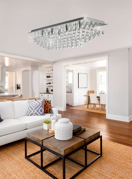 Modern living room with a chandelier, sofa, coffee table, and open floor plan.