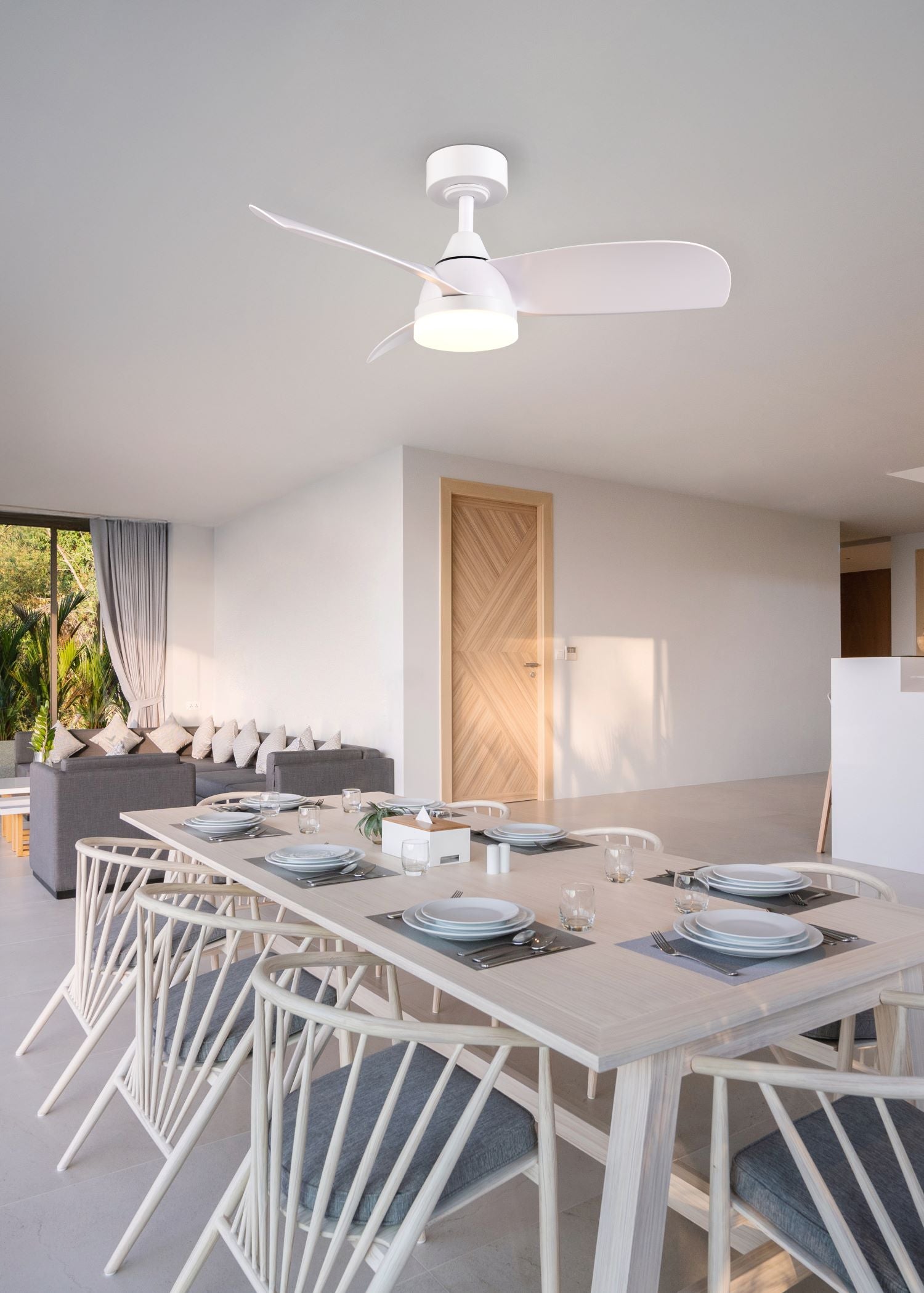 Modern dining room with a ceiling fan, table, and chairs.