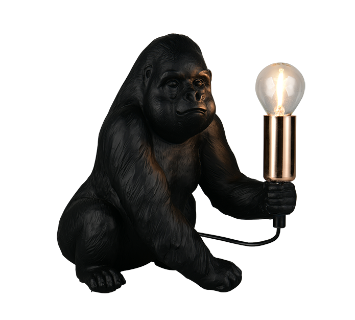 A gorilla-shaped table lamp with a black textured body, holding a glowing clear bulb in a metallic gold holder, shown on a plain white background.