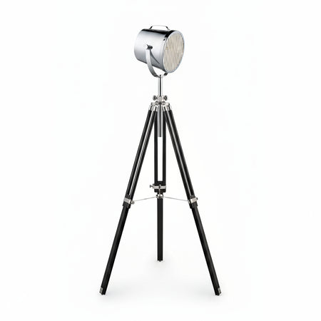 A studio tripod floor lamp with a chrome metal shade and black wood base.